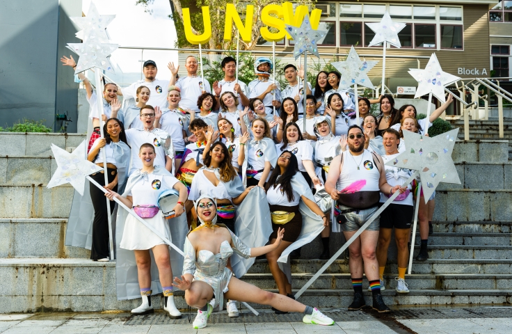 UNSW students and staff in silver galactic outfits on the steps at rehearsal ahead of the parade