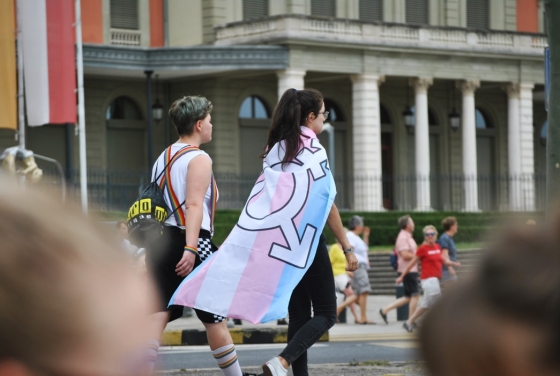 Two people walking with a female flag