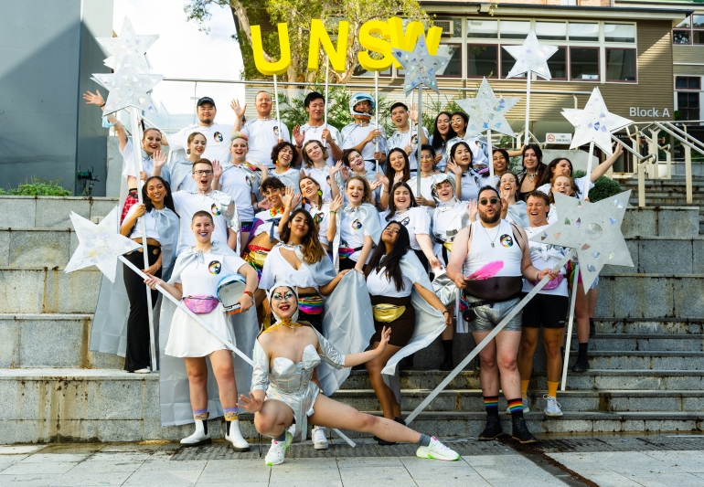UNSW students and staff in silver galactic outfits on the steps at rehearsal ahead of the parade