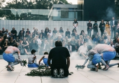 Indigenous men and boys are conducting a smoking ceremony to a crowd