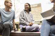 Two students sitting down in front of UNSW tower