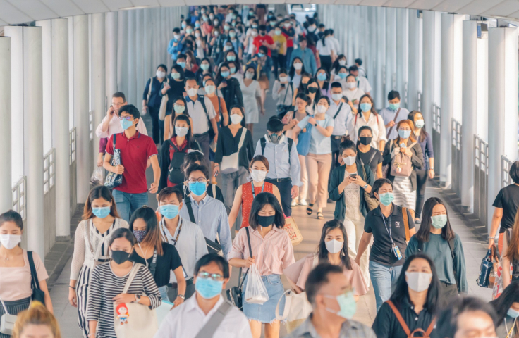 Shot of lots of students walking down a corridor all wearing masks during covid