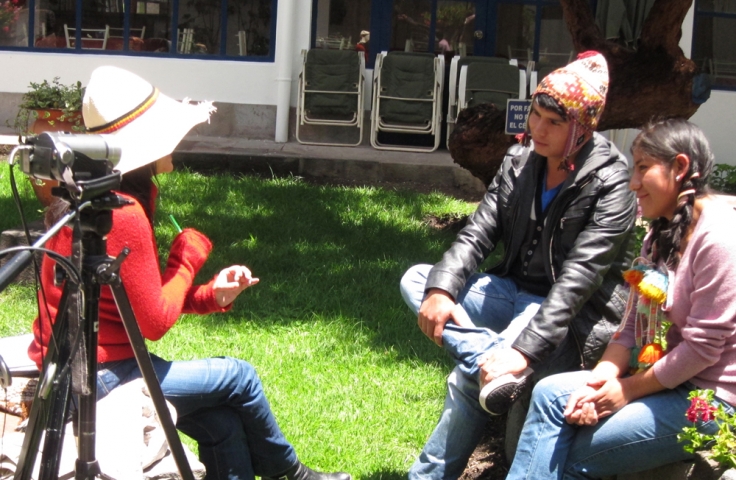 A woman interviews a couple for an interview on camera. 
