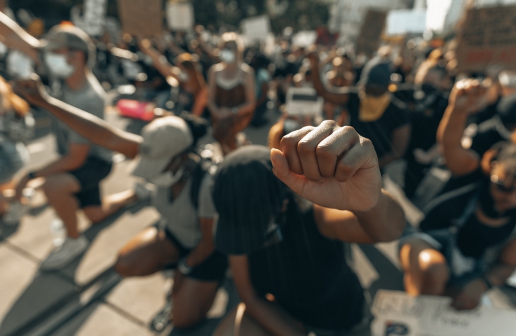 Protesters kneeling and raising a fist