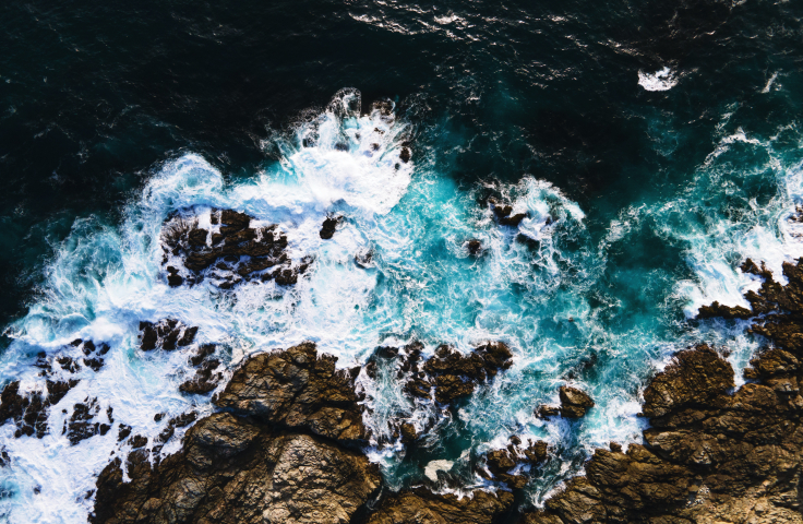 Aerial view of waves crashing on the rocks