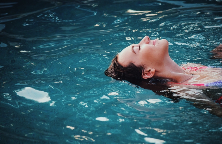 Woman relaxed and floating on her back in a pool