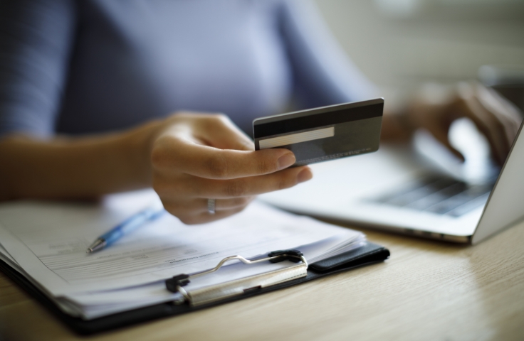 Woman holding a credit card and shopping online