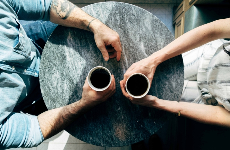 Aerial view of two people sat at a table drinking coffee