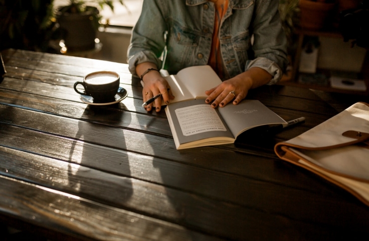 Woman at a cafe reading 